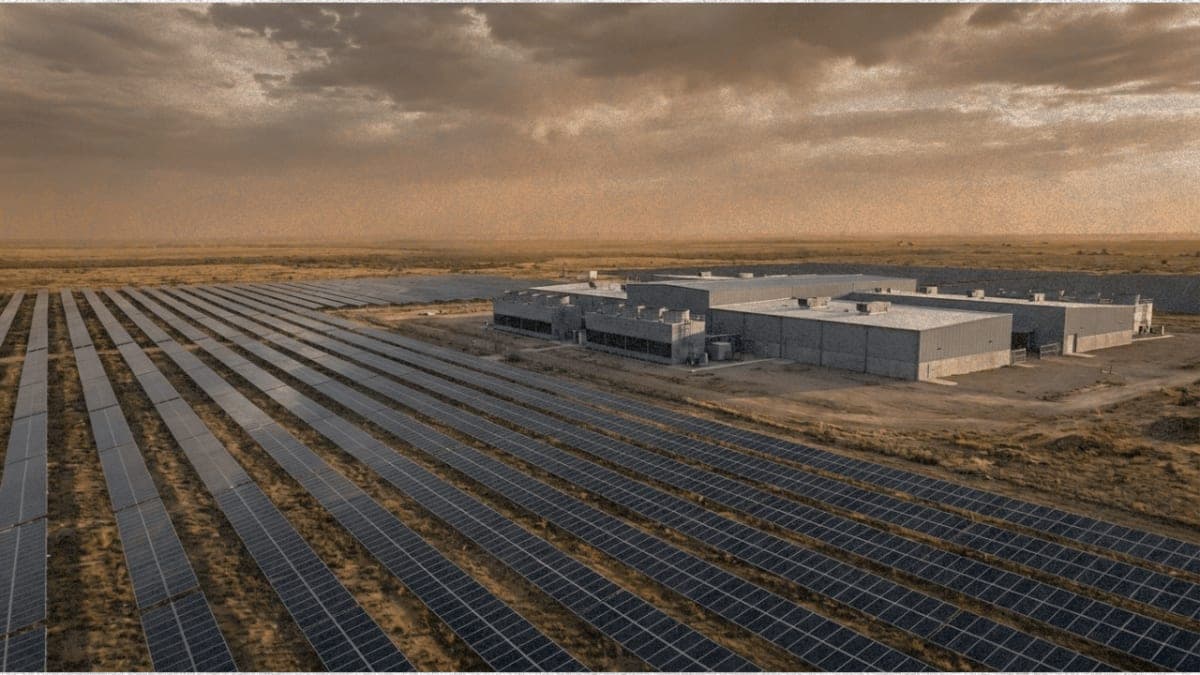 Solar panels stretching across Texas plains with data center facility in the distance at golden hour