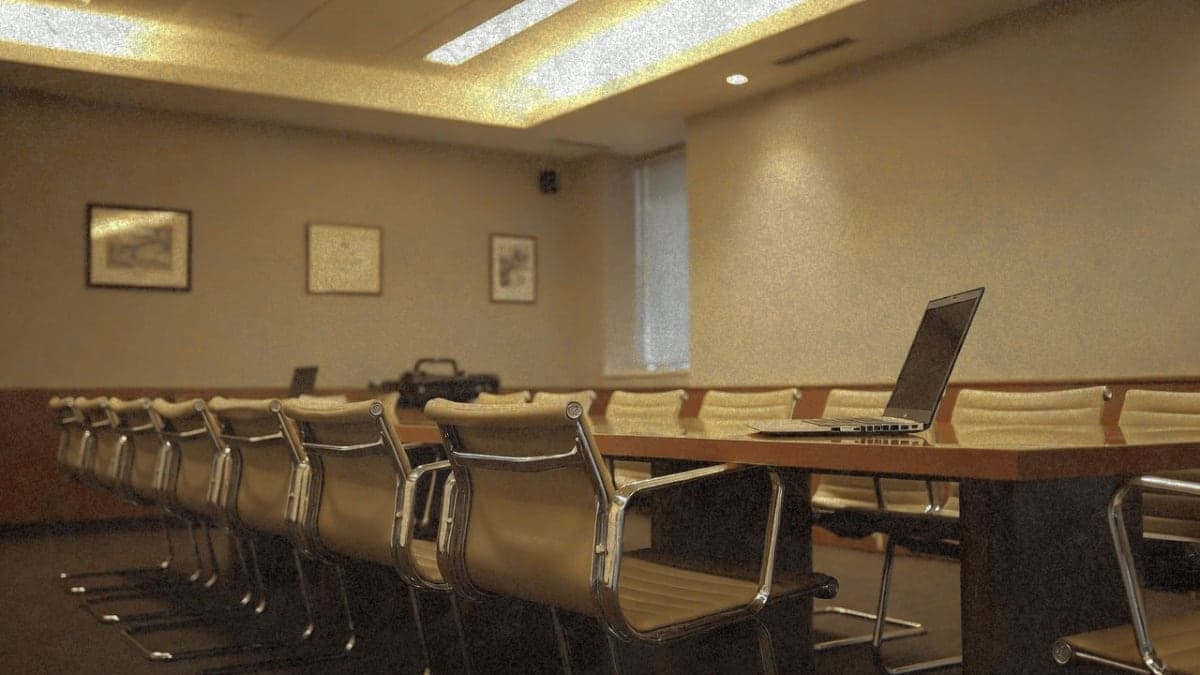 Empty conference room with one chair being removed, suggesting corporate transition