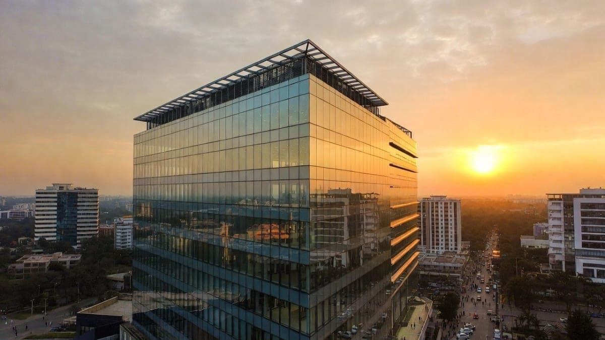 Bengaluru cityscape with modern tech office buildings against a warm sunset sky