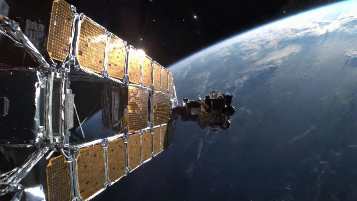 Conceptual rendering of a compact AI satellite with large solar arrays orbiting Earth above cloud cover