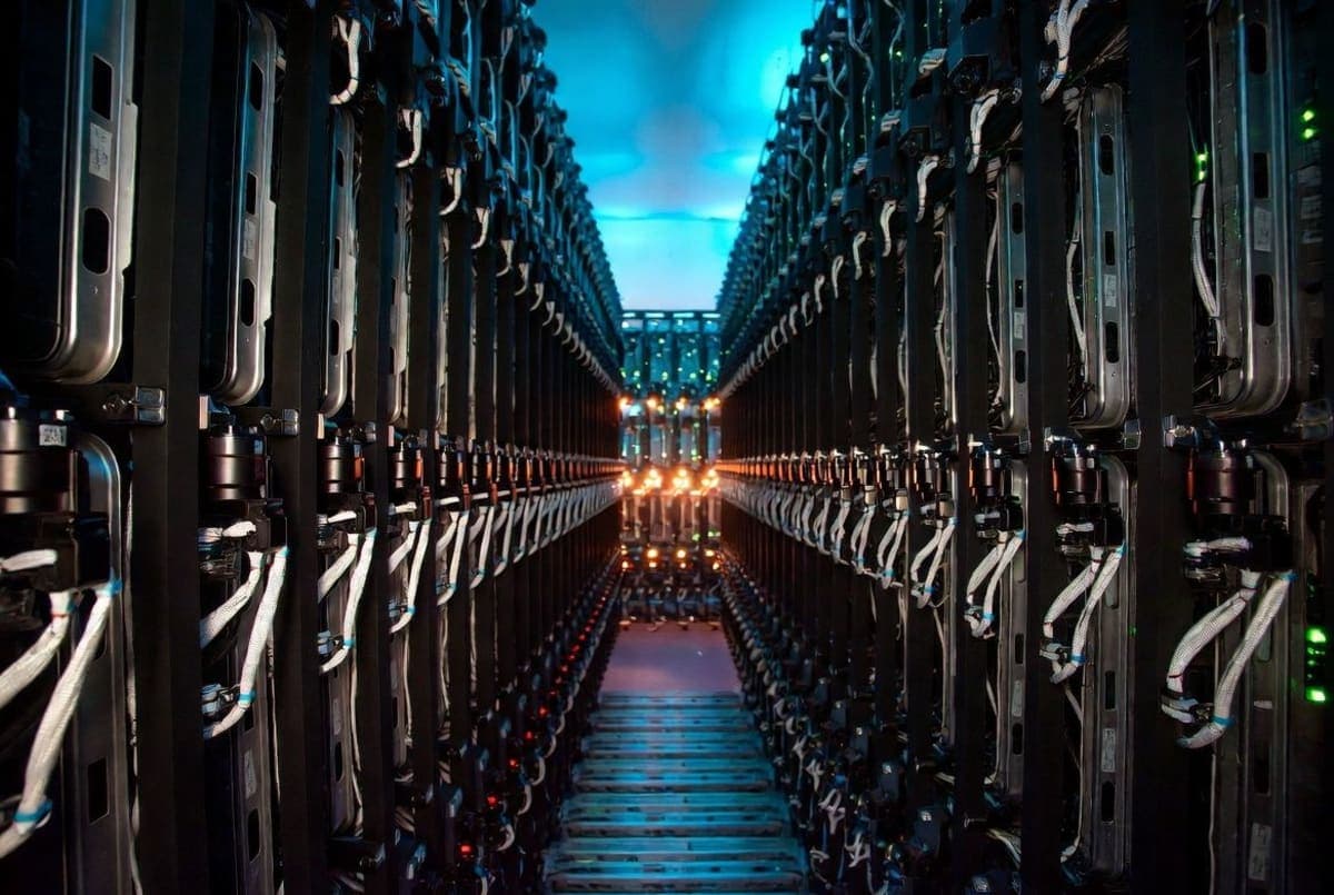 Server racks with status lights glowing amber and red, visualizing infrastructure strain under heavy automated load