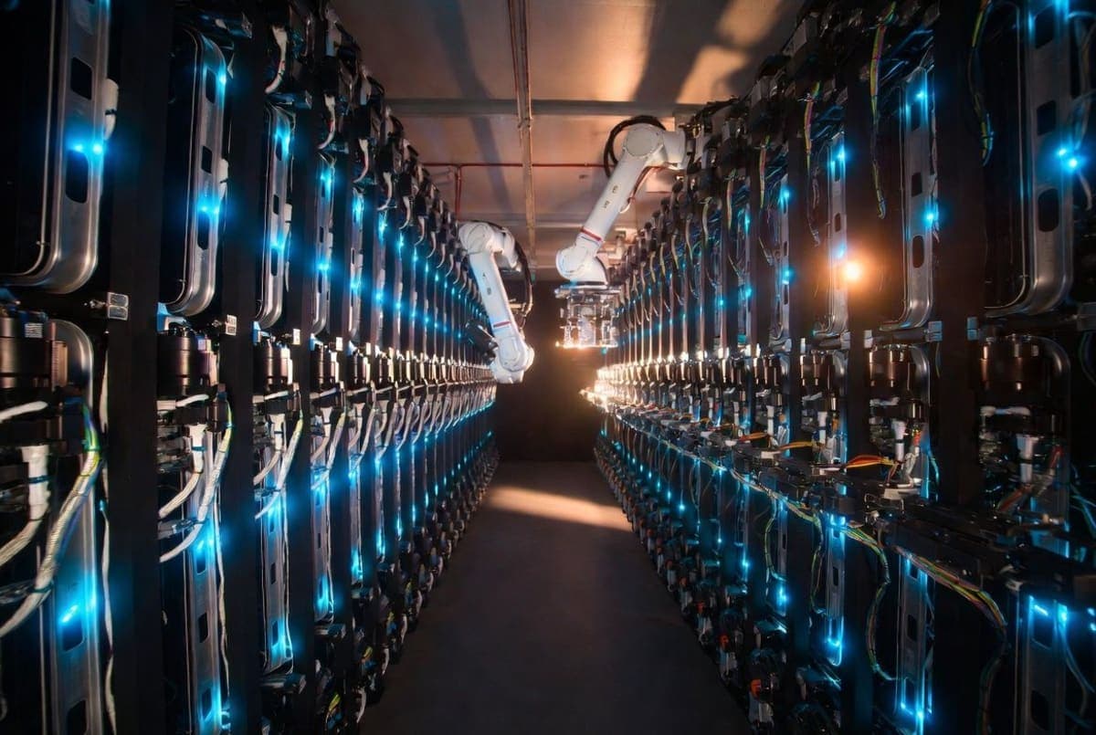 Server racks inside a modern data center with blue LED lighting and rows of custom AI chip infrastructure