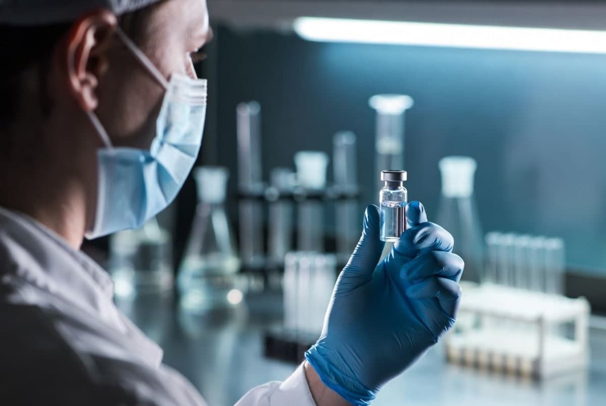 Researcher in a laboratory holding a vial during coronavirus vaccine development